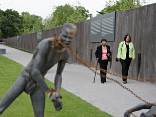People walk past a sculpture at the Equal Justice Initiative’s National Memorial for Peace and Justice in Montgomery, Ala., on Monday.